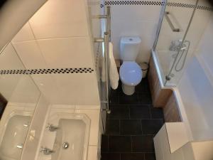 a small bathroom with a toilet and a tub at Little Connaught House in Portsmouth +24 photos