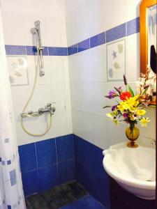 a bathroom with a sink and a vase of flowers at Fanos Studios in Koufonisia