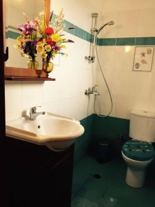a bathroom with a sink and a toilet with flowers at Fanos Studios in Koufonisia