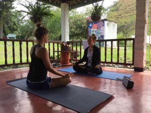two women sitting on the floor in a yoga pose at Ginebra Glamping in Ginebra