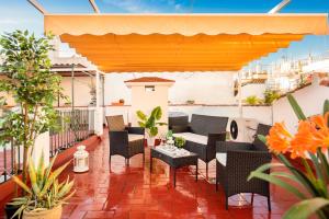 d'une terrasse avec des chaises et des tables sur un balcon. dans l'établissement HSH Suites Barrio Santa Cruz, à Séville