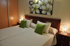 a bedroom with a bed with green and white pillows at Hostal Rural Letur in Letur