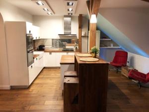 ワルシャワにあるBednarska 18 - Loft by Homeprimeの白いキャビネットと赤い椅子付きのキッチン
