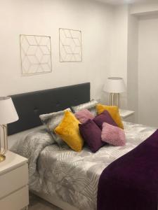 1 cama con almohadas coloridas en el dormitorio en Moderno piso junto al mar. WIFI, en Puerto de la Cruz