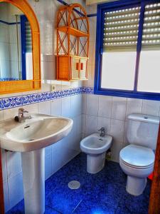 a bathroom with a sink and a toilet and a mirror at Apartamento y Parking en pleno CENTRO, DAMAS in Huelva