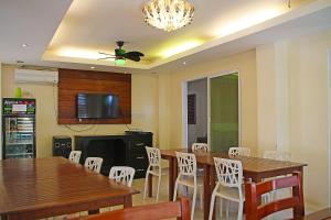 a dining room with wooden tables and white chairs at Giecel Pension in El Nido