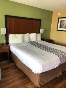 a bedroom with a large bed with a wooden headboard at Knights Inn Motel in Grants Pass