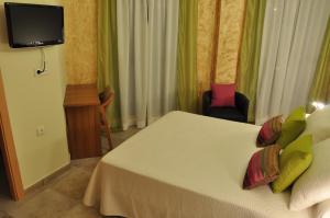 a hotel room with a bed and a tv at Hostal Rural Letur in Letur