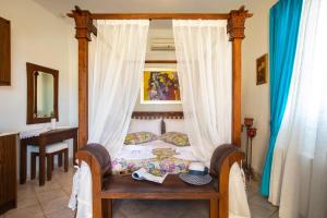 a bedroom with a canopy bed with a table and chairs at Kastro Apartments in Panormos Rethymno