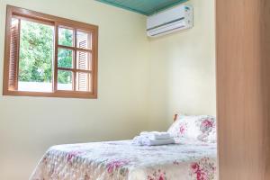 1 dormitorio con cama y ventana en Paradouro Padilha, en Canela