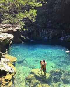two people standing on rocks in a pool of water at Pousada Alvorada in Riachão +24 photos