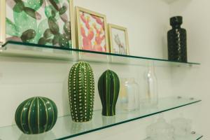 a shelf with three green cactuses on it at Jasmim in Setúbal