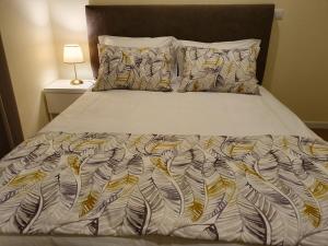 un letto con piumone e cuscini bianchi di Agnelo Comfort - Accommodation H V a Funchal