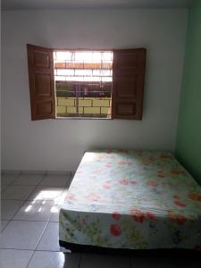 a bed in a room with a window at Casa de Veraneio in Salinópolis