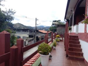 un balcón con una valla roja y macetas en hostel MdeMarilia, en Nova Friburgo