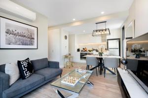a living room with a couch and a table at Manhattan Apartments - Notting Hill in Notting Hill