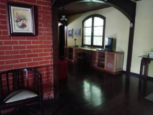 a room with a red brick wall and a window at hostel MdeMarilia in Nova Friburgo