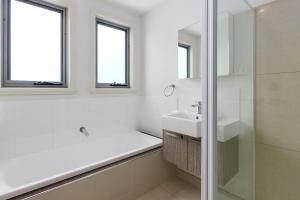 a white bathroom with a sink and a shower at 170 Hazards View Drive - Unit 2 in Coles Bay