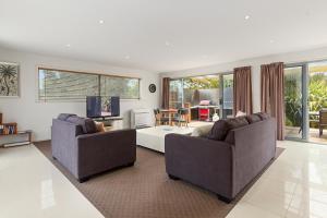 a living room with two couches and a tv at 170 Hazards View Drive - Unit 2 in Coles Bay