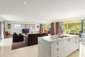 a kitchen and living room with a couch and a tv at 170 Hazards View Drive - Unit 2 in Coles Bay