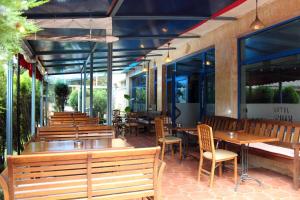 un ristorante con panche e tavoli in legno e finestre di Fenix Family Hotel a Blagoevgrad