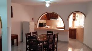 a kitchen with a table and chairs and an archway at El Jardín Del Edén in Tequisquiapan