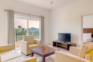 a living room with a couch and a television and a bed at Fairway Sunset Serviced Apartments in Galle