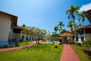 a resort yard with a swimming pool and palm trees at Villea Morib in Morib