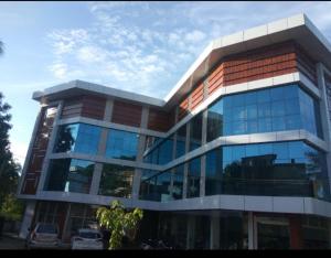 a large glass building with cars parked in front of it at Apsara Residency in Perintalmanna