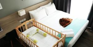 sypialnia z łóżeczkiem dziecięcym z dwiema dziećmi w obiekcie Singgah Kertih w Kerteh