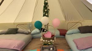 a tent with two beds and balloons in it at Glamping Kaki - Large Bell Tent in Singapore