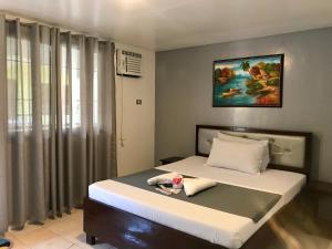 - une chambre avec un lit et une peinture murale dans l'établissement Marion Roos Hotel, à Puerto Galera