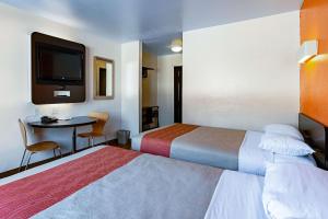ein Hotelzimmer mit 2 Betten, einem Tisch und einem TV in der Unterkunft Motel 6-Palatine, IL - Chicago Northwest in Palatine