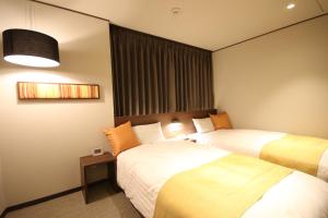 um quarto de hotel com duas camas e uma janela em Kita Hotel em Morioka