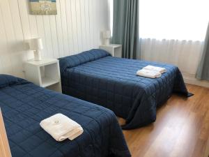 Dos camas en una habitación de hotel con toallas encima. en Colony Inn Hotel, en Jerilderie