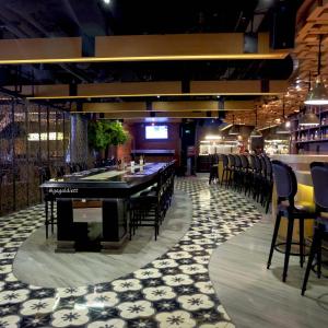 un restaurante con un bar con mesa y sillas en Whiz Prime Hotel Kelapa Gading en Yakarta