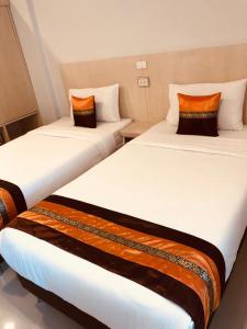 two beds sitting next to each other in a room at Chiangmun Boutique in Chiang Mai