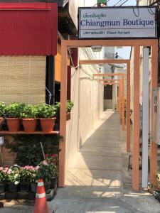 a sign for a building with potted plants and a corridor at Chiangmun Boutique in Chiang Mai +20 photos