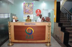 a reception desk in a building with two people behind it at Green Grande Inn in Chennai