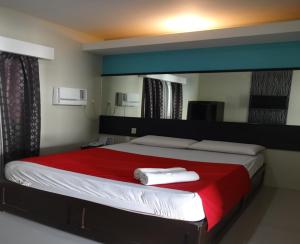 um quarto com uma cama grande e um cobertor vermelho em Heilee's Guest House em General Santos