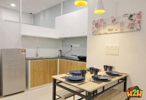 uma cozinha com uma mesa com pratos azuis em H2H - Sweet Cottage - Octagon em Ipoh