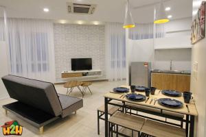 cocina y sala de estar con mesa y sillas en H2H - Sweet Cottage - Octagon en Ipoh