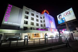 a building with signs on the side of it at night at Regency Tirunelveli By GRT Hotels in Tirunelveli