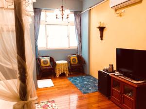 sala de estar con TV, sillas y ventana en Hope & Sea Homestay, en Hualien City