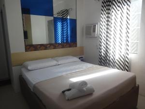 um quarto com uma cama com uma toalha em Heilee's Guest House em General Santos
