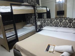 um quarto com 2 beliches e um controlo remoto sobre uma mesa em Heilee's Guest House em General Santos