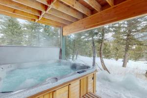 a hot tub in a cabin in the snow at Antler Ridge in Big Sky