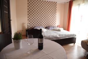 a bottle of wine sitting on a table in a bedroom at Nestor II in Mrzeżyno