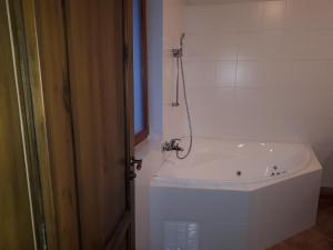 Una bañera blanca en un baño con ventana. en Apartman Kuka Tatranská Lomnica, en Tatranská Lomnica 40 fotos más