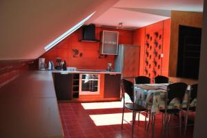 a kitchen with red walls and a table and chairs at Nestor II in Mrzeżyno